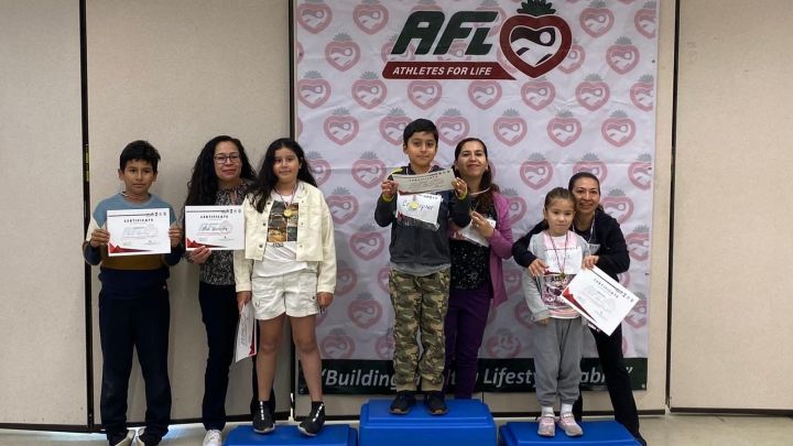 Children Winning the Athletes for life Award Certificate on a podium