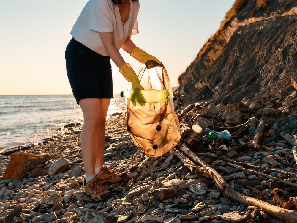 Person picking up trash on beach